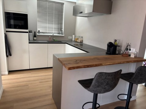 Foto : Stijlvolle keuken met roestvrijstalen werkblad en warme houten accenten