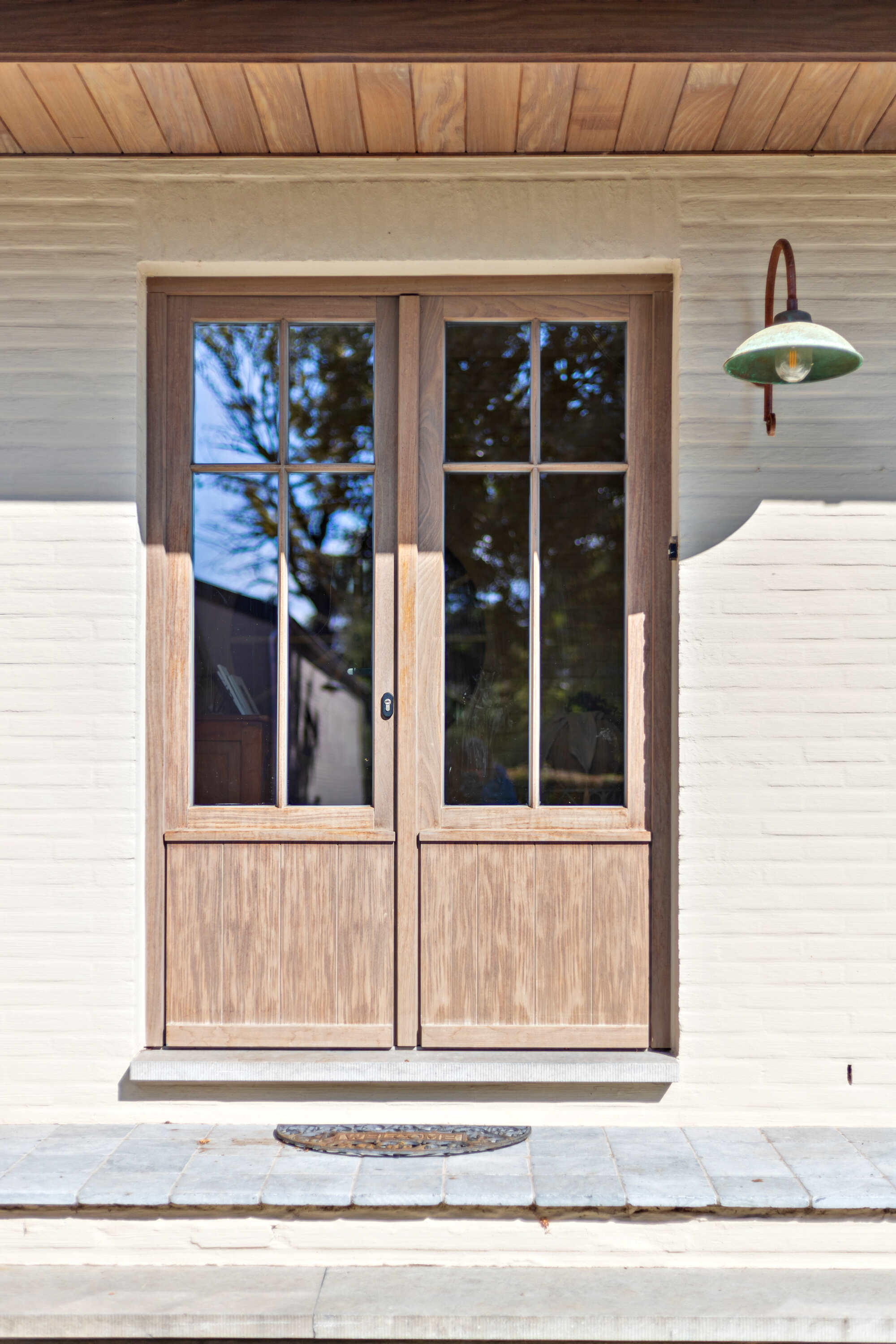 Landelijke dubbele houten voordeur met beglazing en verdelingen.