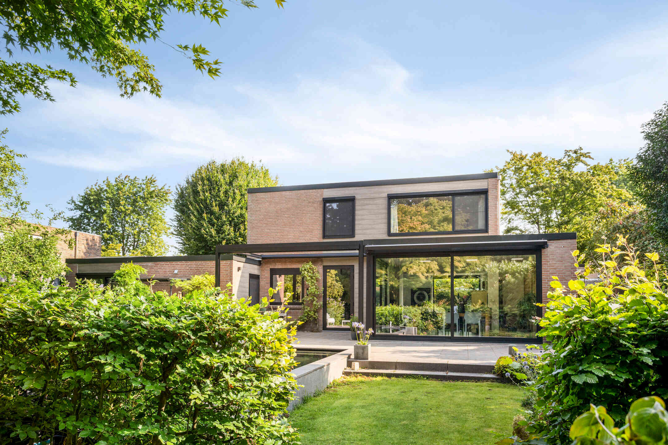 Terras met schuifpuien geborgen in het groen