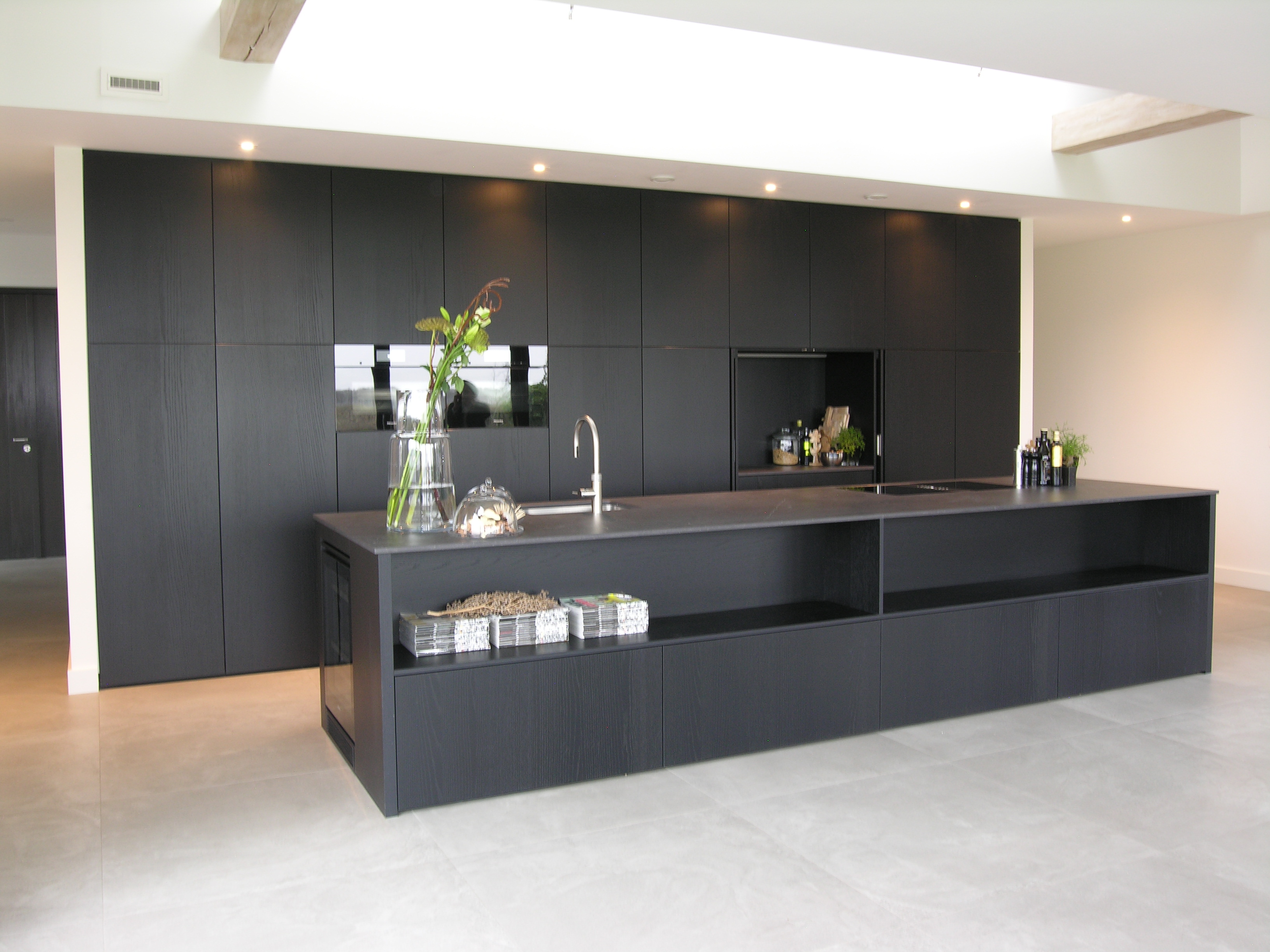 Strakke greeploze keuken met houtstructuur - keukenblad - keuken - WONEN.nl