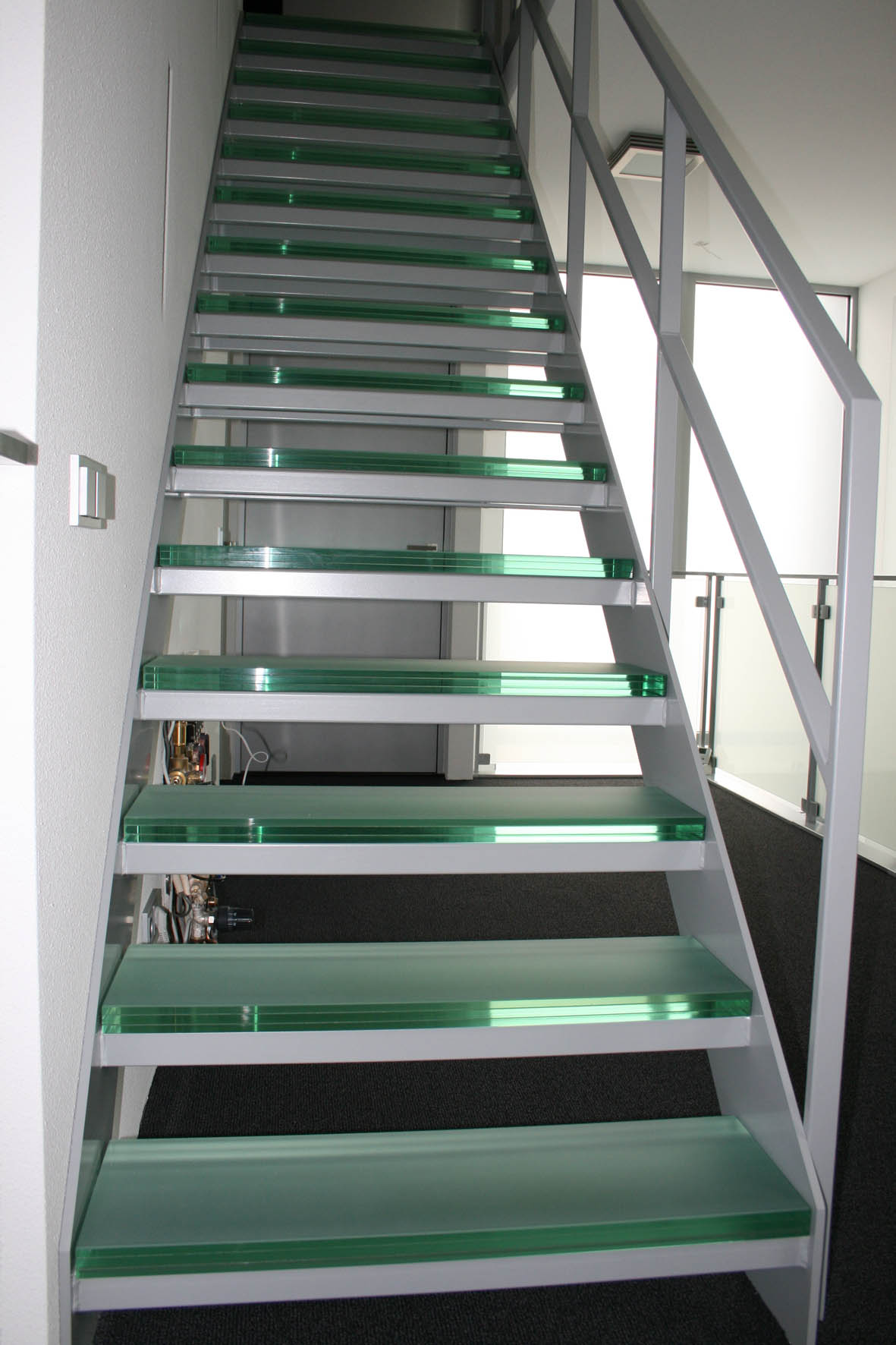 Foto : Een adembenemende open stalen steektrap met glazen treden